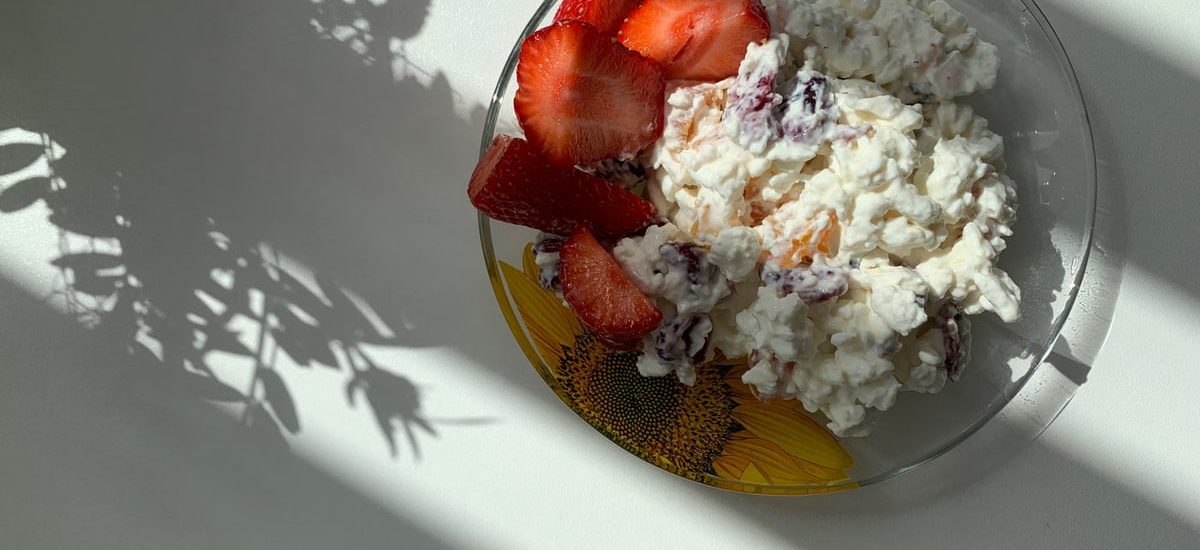 A sunlit plate of strawberries and cottage cheese perfect for breakfast.